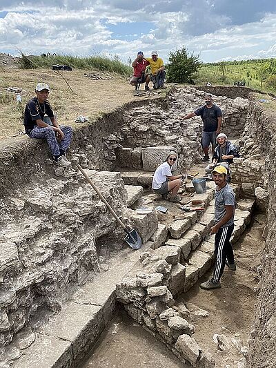 Photo du site d'archéologie avec une partie de l'équipe internationale